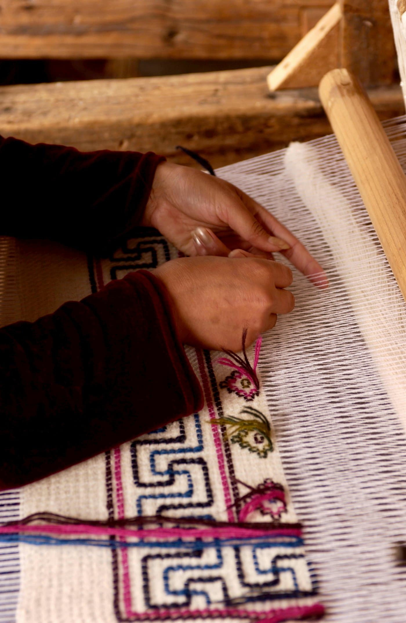 Hands finishing a hand-woven textile