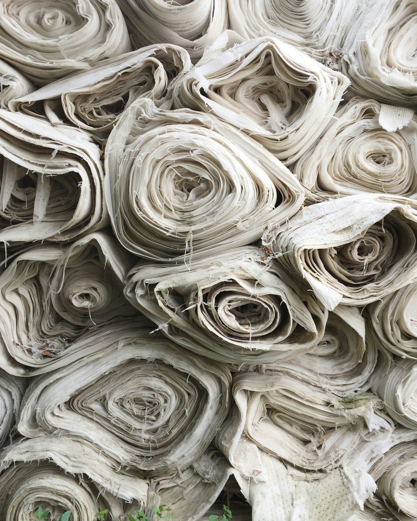 Bolts of raw fabric rolled and stacked at the mill